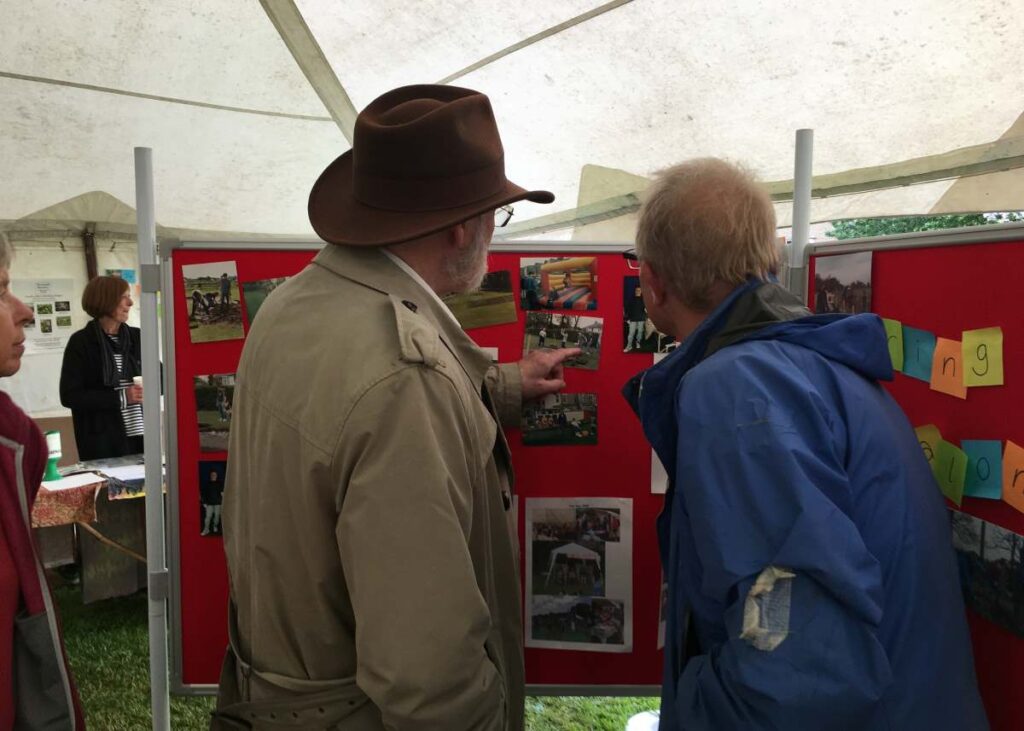 Two men looking at photos on Sharing Our Heritage Exhibition board 2016