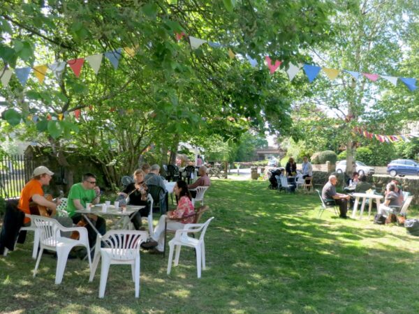 People attending the stalls, treasure trail and BBQ at the Triangle in the sunshine