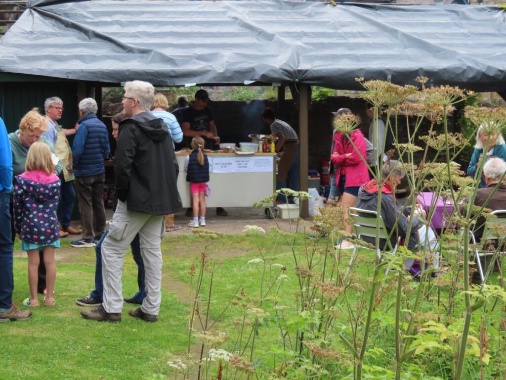 People standing with BBQ in background -Triangle Summer Fair August 2025